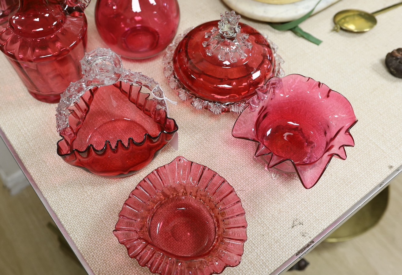 A Victorian cranberry glass decanters, a powder bowl, basket, two vases and two bowls., Tallest decanter 30 cms high.